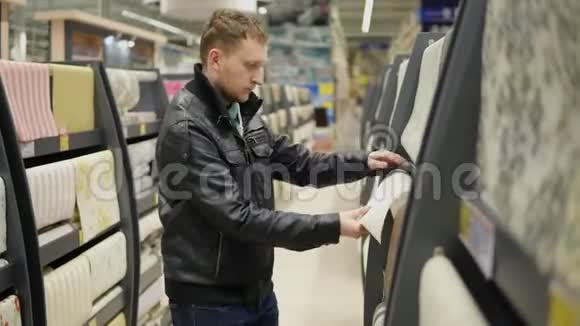 年轻人在超市里选择壁纸他看着壁纸摸着它想着哪一张视频的预览图