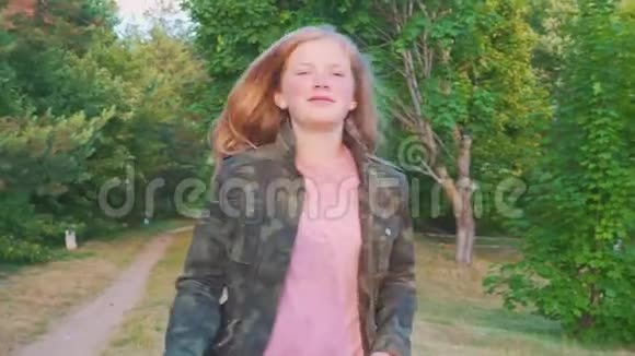 一个留着长发的少女在树林里的小径上奔跑女孩沿着森林小径跑视频的预览图