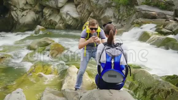 丈夫在一条山河上风景如画的地方给妻子拍照一起快乐时光活跃而快乐视频的预览图