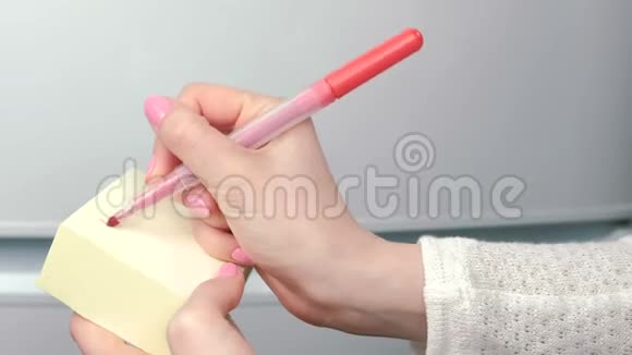特写女的手写在黄色的贴纸纸上字买牛奶面包鸡肉家庭笔记视频的预览图