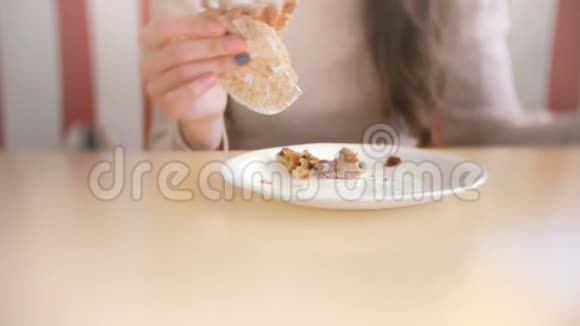 女人吃松饼和葡萄干女人的手特写视频的预览图