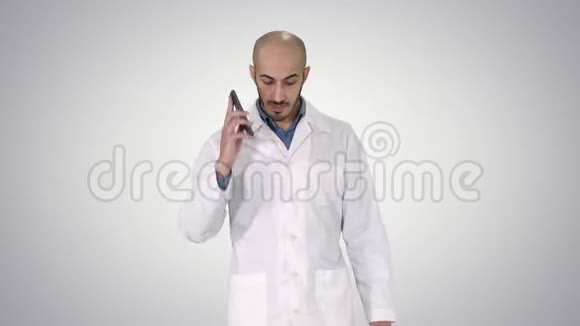 专业医生在梯度背景下边走边打手机视频的预览图