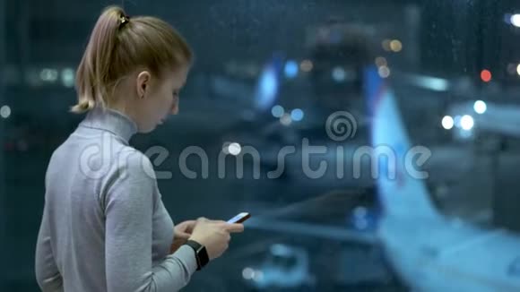 在机场打电话给朋友或亲戚的年轻女孩在等航班女孩在候机楼打手机视频的预览图