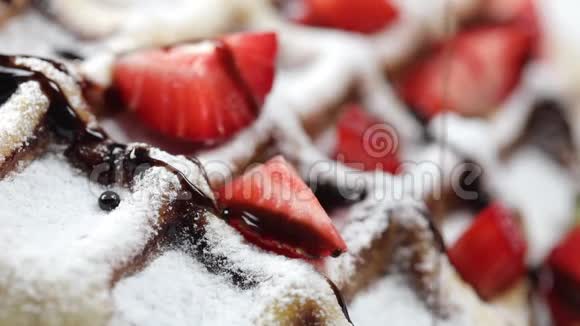 比利时华夫饼盘子里放着新鲜草莓将热巧克力倒入华夫饼视频的预览图