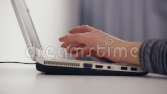 商务女性的特写她的手在笔记本电脑键盘上打字侧视女性手在笔记本电脑上打字慢动作视频的预览图