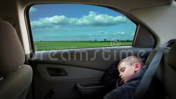 小男孩睡在车椅上高速行驶的汽车视频的预览图