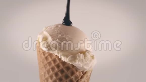 将巧克力酱倒在冰淇淋筒上特写镜头视频的预览图