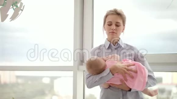 疲惫的母亲手牵着孩子靠近窗户做生意的母亲视频的预览图