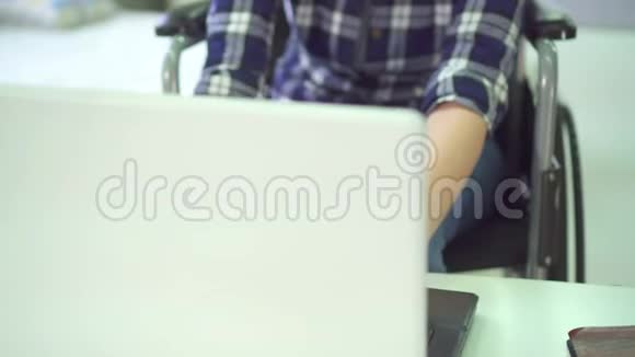 键盘打字残疾青年妇女轮椅家庭远程工作电脑耳机视频的预览图