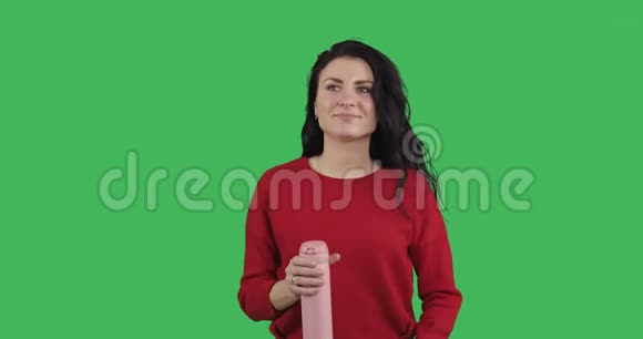 迷人的黑发女人走路和喝茶从粉红色热杯视频的预览图