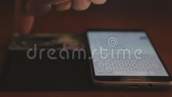 男人用智能手机和信用卡在线支付专注于手指夹起来视频的预览图