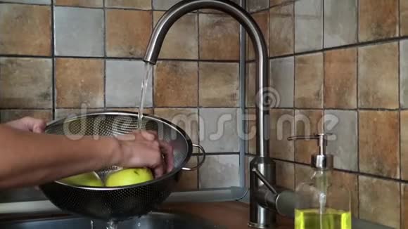 女人的手在水龙头下洗青苹果慢动作视频视频的预览图