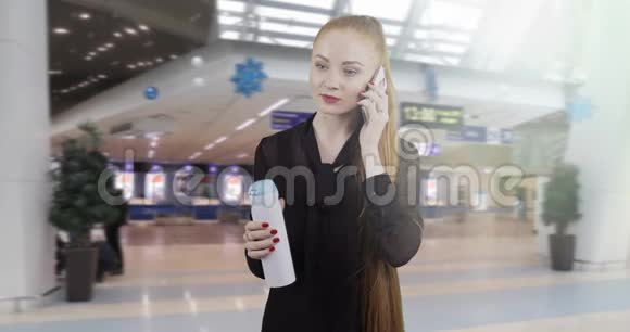 年轻的商界女性留着红色长发在手机上交谈视频的预览图