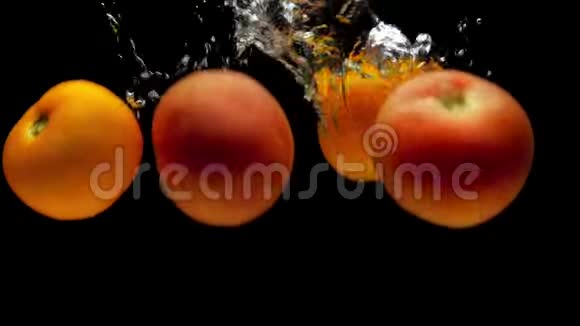 红色和黄色的番茄在黑色背景的透明水中落下视频的预览图