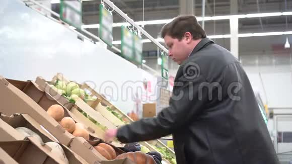 年轻人在超市里挑选南瓜蔬菜准备万圣节或蔬菜饮食视频的预览图