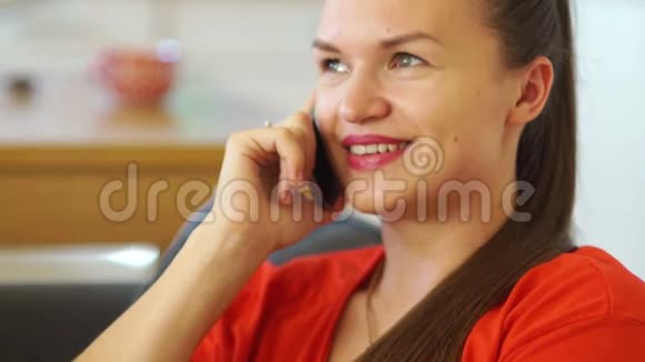 可爱的漂亮女孩在手机上说话穿红色裙子的女商人移动连接慢动作视频的预览图