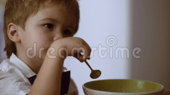 儿童独立概念男孩吃粥小孩吃粥看动画片视频的预览图