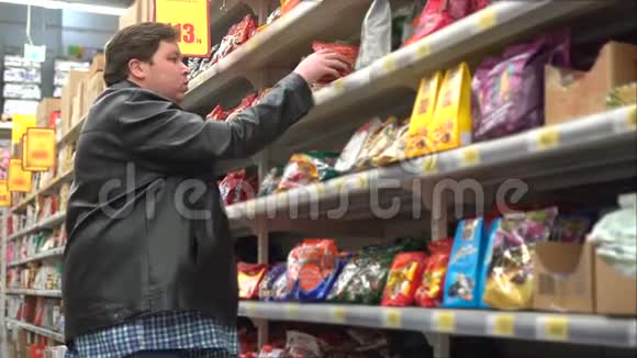 年轻人在超市的糖果区挑选零食视频的预览图