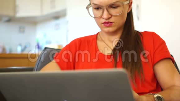 那个穿红衣服的女孩厌倦了在电脑上工作他摘下眼镜揉了揉眼睛特写肖像视频的预览图