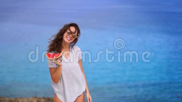 美丽的女人在海边吃西瓜好好享受假期吧暑假快乐视频的预览图