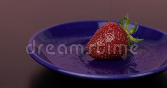 成熟多汁的草莓倒在黑背景的巧克力上关门视频的预览图