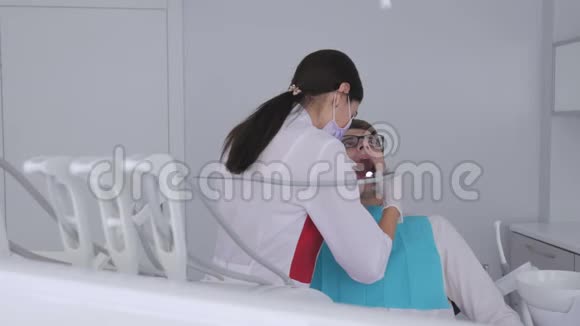 一位女牙医用钻头给坐在牙科椅上的病人钻牙视频的预览图