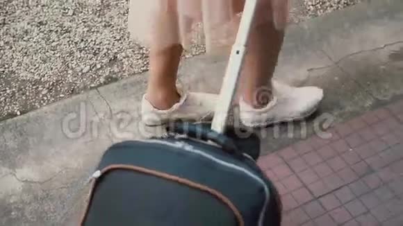 后景的旅客女士腿走路与手提箱在街上带背包的女孩走出了入口视频的预览图