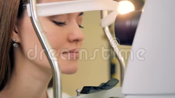 一个女人向前倾斜让她的眼睛被一台医疗机器测试视频的预览图