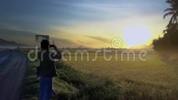 女孩制作日出视频从道路附近的水稻种植视频的预览图