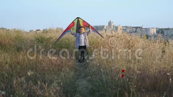 快乐美丽的男孩手里拿着五颜六色的风筝奔跑视频的预览图