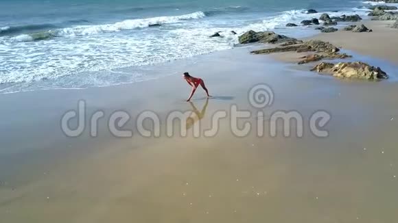 沙滩上的泡沫浪潮和瑜伽姿势中的女孩视频的预览图