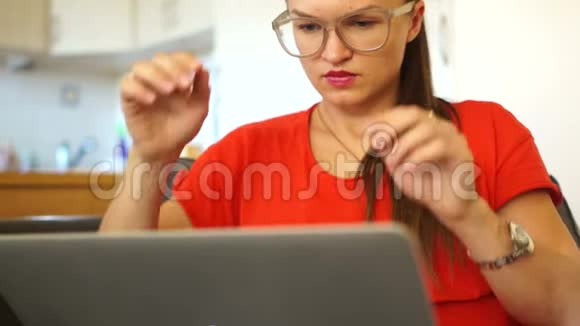 一名女性自由职业者擦拭她的眼睛戴眼镜并继续工作远程就业在办公室工作视频的预览图