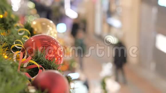 商场里喜庆的气氛前景中一个新年红球不在焦点的人走路和买礼物视频的预览图