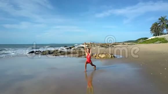 女子练习瑜伽玫瑰在海滩与棕榈视频的预览图