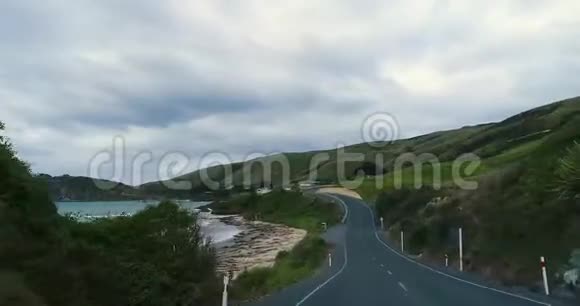 沿着蜿蜒的道路旅行穿过靠近海岸的山丘带着岩石视频的预览图