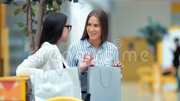 两位美丽的年轻女士在商场购物后休息和讨论一些事情视频的预览图