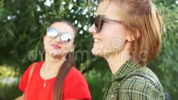 丢失了一对戴太阳镜的女朋友的肖像在公园里散步友谊关系暑假假期视频的预览图