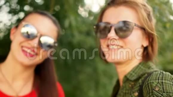 两个年轻快乐的女孩脸上洋溢着快乐的笑容的肖像一对深色头发的女朋友在里面散步视频的预览图