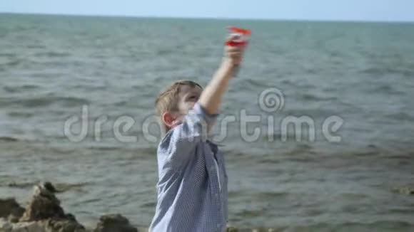 快乐的小男孩控制着在海滩上放飞五颜六色的风筝视频的预览图