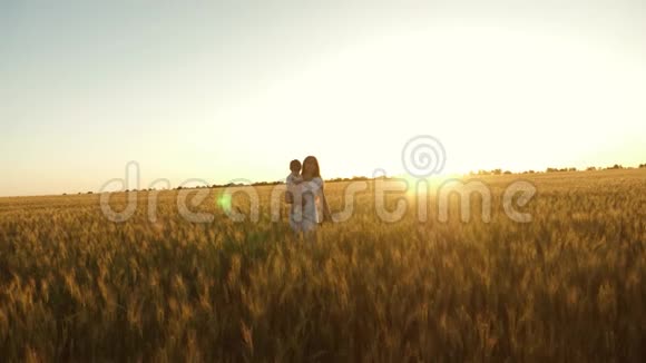 幸福的女儿和她的妈妈正走过成熟的小麦地皱巴巴的幸福家庭和视频的预览图