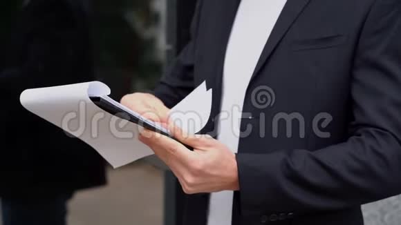 穿西装的年轻人的手检查审查文件公用事业账单报告在办公室附近的商人视频的预览图
