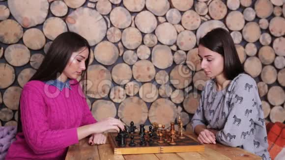 两个漂亮的女人在木桌上下棋英译汉1遵循这种策略的女孩比对手身材好赢了视频的预览图