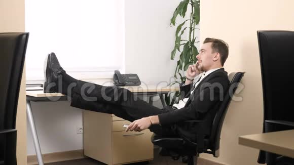 年轻人坐在办公室用手机说话调整空调60英尺视频的预览图