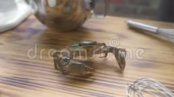 海鲜餐厅厨房的木桌上爬着螃蟹在餐桌上摆着食物配料的活蟹视频的预览图