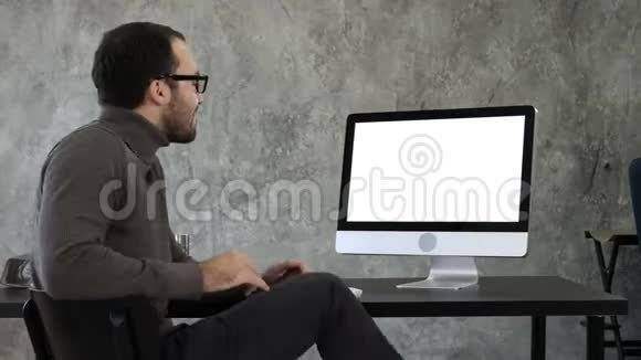 自信的年轻人看着相机在电脑屏幕附近以非常自信的方式交谈白色显示器视频的预览图