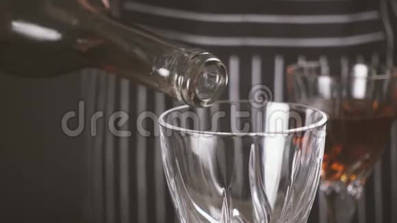 慢动作一个人从瓶子里把酒倒入水晶杯视频的预览图