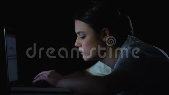 女学生深夜在笔记本电脑上打字从事文凭项目视频的预览图