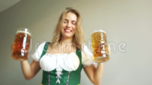 把杯子和啤酒粘在一起在音乐节上穿着巴伐利亚民族服装的漂亮女孩民族传统视频的预览图
