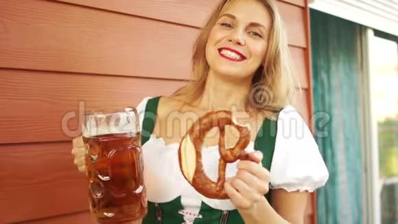 有啤酒和椒盐脆饼的女孩节的酒吧女招待白齿微笑红唇真诚的喜悦国家巴伐利亚州视频的预览图