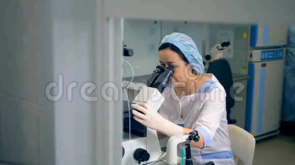 一名妇女使用实验室显微镜视频的预览图